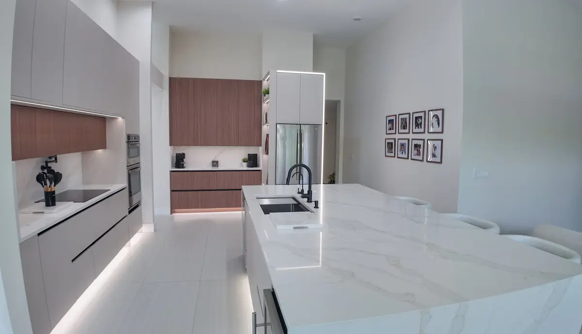 Custom kitchen island with a quartz waterfall countertop, sink and bar seating in a San Diego home